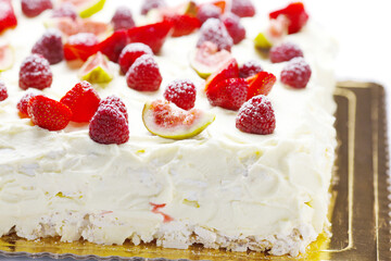 meringue cake with whipped cream and berries - strawberries, raspberries, figs on white