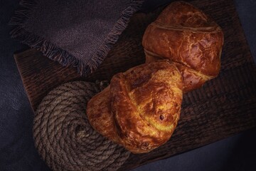 Vintage background with croissants on a stand made of old natural wood, a slide made of old rope.