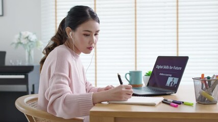 Side view young asian woman listen watch digital class e-learning online for employee reskill upskill on notebook computer at home office workplace. Business school lesson education for adult people.