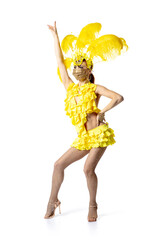 Face mask. Beautiful young woman in carnival, stylish masquerade costume with feathers dancing on white studio background. Concept of holidays celebration, festive time, dance, party, having fun.