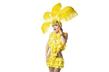 Performing. Beautiful young woman in carnival masquerade costume with yellow feathers dancing on white background. Concept of holidays celebration, festive time, dance, party, happiness. Copyspace