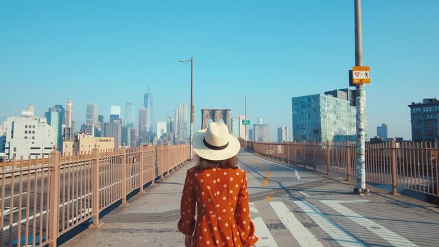 Attractive girl walking across the Brooklyn Bridge in New York