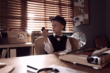 Cute little detective with smoking pipe at table in office