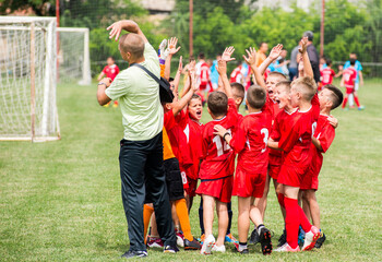 Naklejka premium happy young children players celebrating in hug after victory