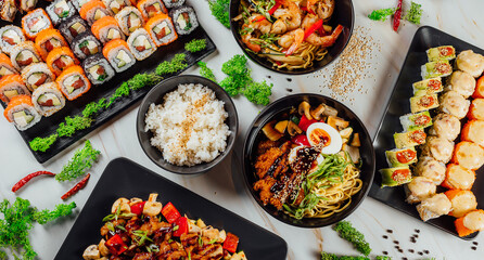 High angle shot of plates with traditional Asian food, seafood, and sushi on a table.. - Powered by Adobe