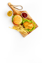 Top view of delicious burgers on on wooden board. Fried potatoes and chicken