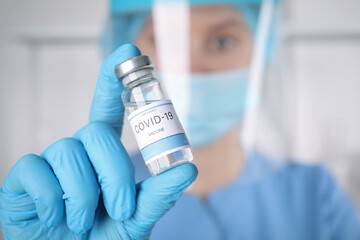 Doctor with coronavirus vaccine in laboratory, focus on hand