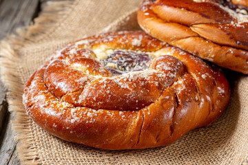 Buns with jam on a wooden table. Pie with cherry jam and marzipan. Rustic delicious pastries	