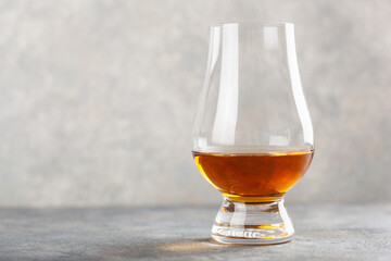 glass of whisky spirit brandy on gray concrete background