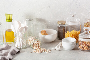 kitchen utensils on modern simple counter, kitchenware jars with dry ingredients bowls