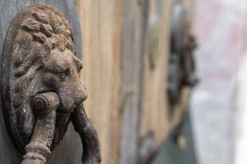 Close-up of a metal knob in the shape of a lion's head, made of rusty iron