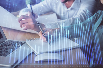 Double exposure of forex chart drawing over people taking notes background. Concept of financial analysis