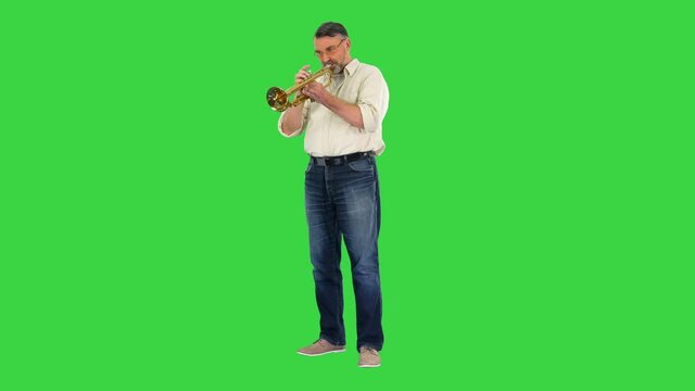 Senior musician playing a trumpet on a Green Screen, Chroma Key.