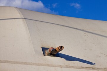 Two rusted air pipes come out of a plastic pressure switch cover of a sports building (Pesaro,...