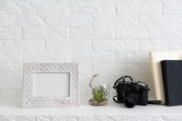 White wall interior with decoration book, and plant pots on the shelf