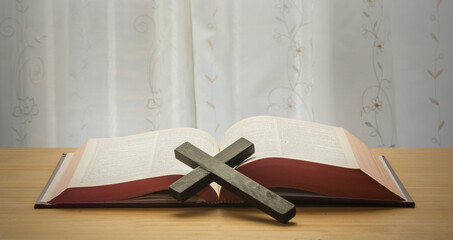 Bible on the table. A cross on the table.