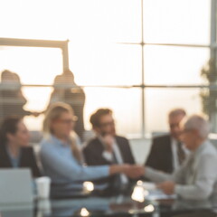 blurry image of a handshake of business people at a meeting in the office.