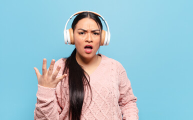 hispanic woman looking angry, annoyed and frustrated screaming wtf or what’s wrong with you