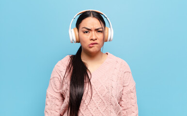 hispanic woman looking puzzled and confused, biting lip with a nervous gesture, not knowing the...