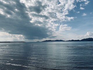 Seascape with mountains background, cloudy sky