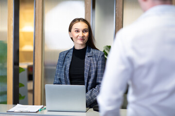 receptionist who is willing to serve you. attractive receptionist at desk in hotel lobby