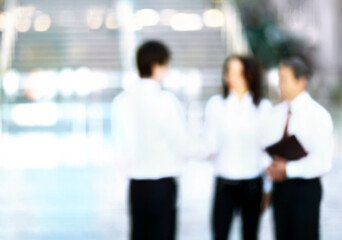 blurry image of a handshake of business people standing in the office.