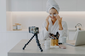 Pretty happy female blogger records streaming video for her blog gives tutorial how to apply beauty...