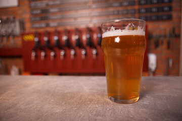 Close up of light beer in a glass on the counter at beer pub