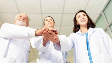 Obraz premium Close up hands team of medical workers holding hands together in hospital. Group doctor coordinate hands for success work. Health care Concept