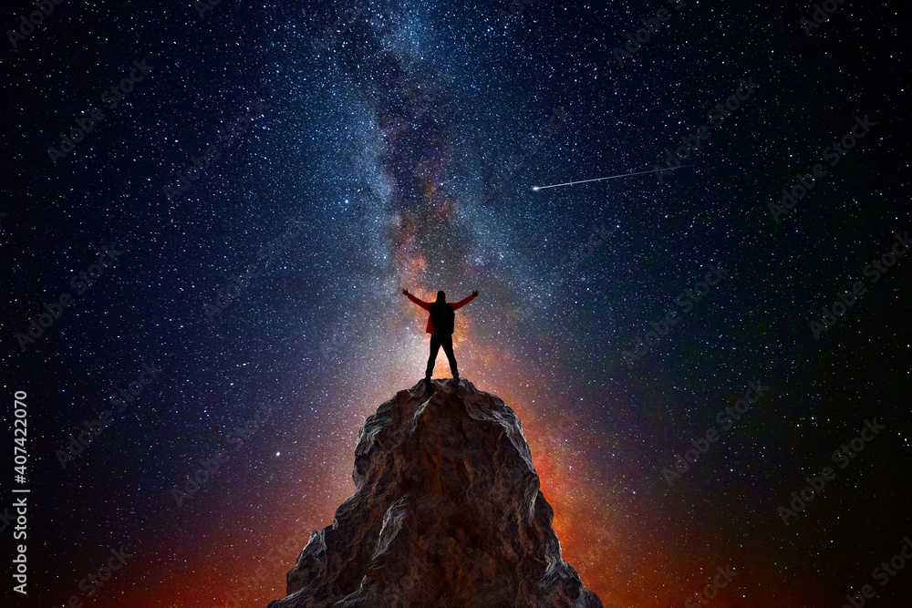 Wall mural man on top of a mountain observing the universe