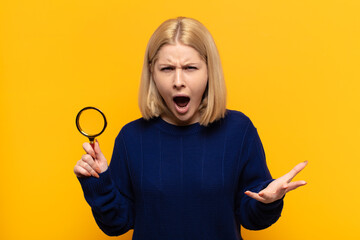 blonde woman looking angry, annoyed and frustrated screaming wtf or what’s wrong with you