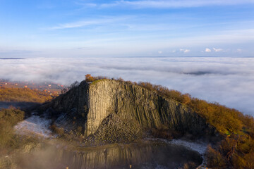 Monoszló, Hungary - Aerial view of volcanic basalt rock formation named Hegyestű with fog over...