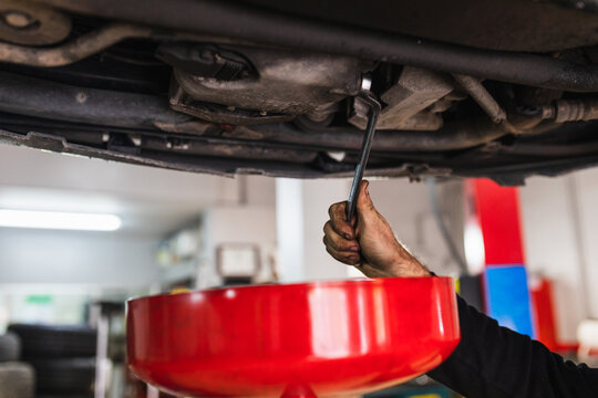 Hands of a mechanic changing the oil of the car. concept car mechanics