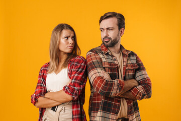 Charming unhappy couple posing with arms crossed