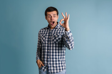 Fototapeta premium Excited young guy exclaiming while showing ok sign gesture
