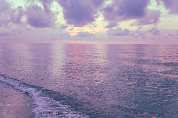 Early morning on the beach. Pink-purple dawn over the sea. Pastel color
