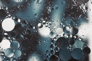 Oil with water round different sizes bubbles in blue and dark grey tones blur effect macro