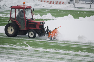 Removing snow with tractor from the soccer pitch.