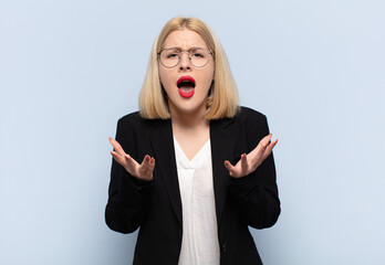 blonde woman looking desperate and frustrated, stressed, unhappy and annoyed, shouting and screaming