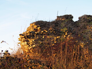 autumn afternoon in the woods near the ruins of an old stone castle, sunny cold day, wild nature, adventure trip, travel