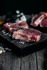 Raw pork steak on the bone on a wooden table. Cooking meat