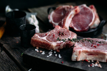 Raw pork steak on the bone on a wooden table. Cooking meat