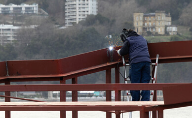 A construction worker welding a structure 