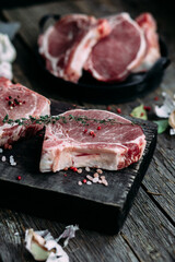 Raw pork steak on the bone on a wooden table. Cooking meat