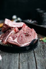 Raw pork steak on the bone on a wooden table. Cooking meat