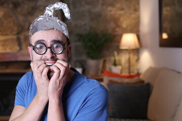 Paranoid man wearing weird tinfoil hat  - obrazy, fototapety, plakaty
