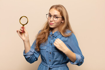 blonde woman looking arrogant, successful, positive and proud, pointing to self