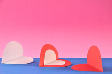 three hearts with pink background and space for text
