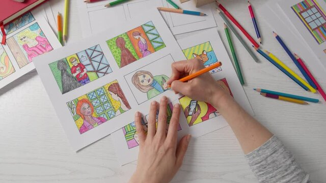 An artist draws a comic book storyboard on paper.