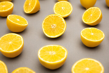 Fototapeta premium row of fresh and ripe lemons halves on grey